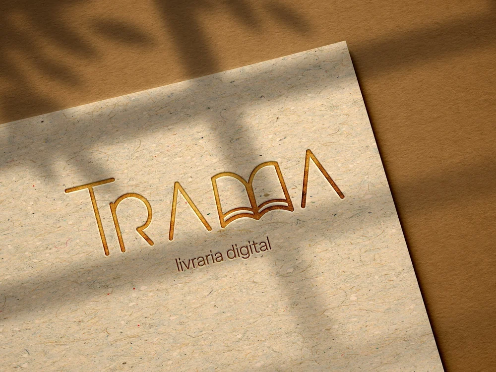 Logo da Trama em relevo sobre papel kraft, sob a sombra de uma janela